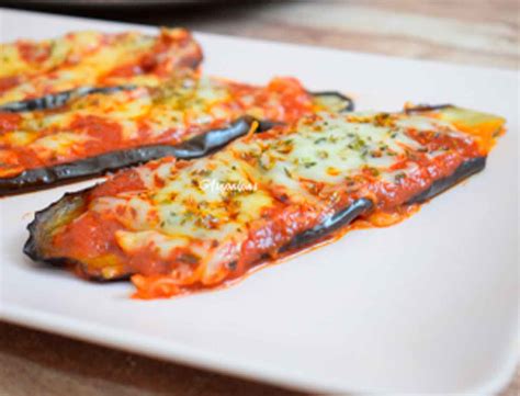 Berenjenas enteras con una cobertura de mezcla de tomate y especias en una bandeja de horno