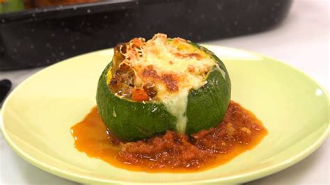 Plato de berenjenas y zapallitos asados con una capa de crema de palta y hojas verdes