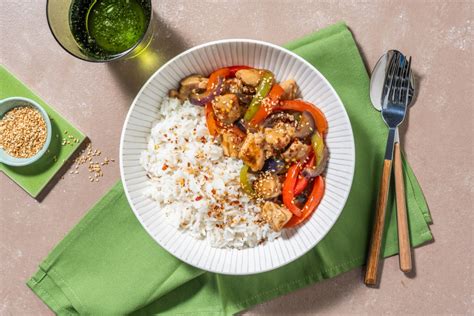 Plato de pollo teriyaki con verduras y arroz, decorado con sésamo