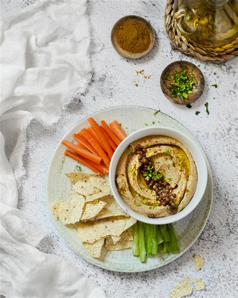 Fotografía de hummus de lentejas servido con crudités y pimentón
