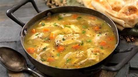 Foto de una persona tomando una sopa de pollo caliente y reconfortante