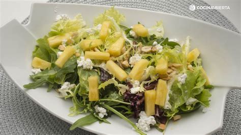 Plato de ensalada de piña, lechugas variadas y requesón con anacardos
