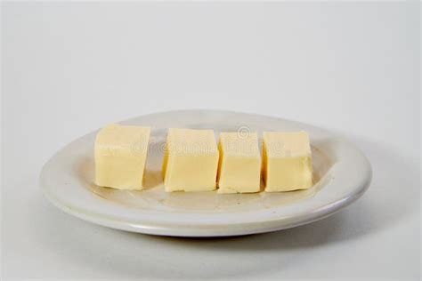 Imagen comparativa de un trozo de mantequilla y un envase de margarina