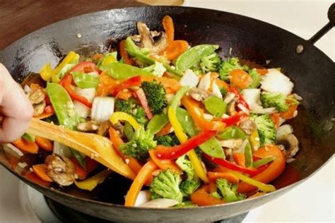 Fotografía de una sartén con verduras salteadas (cebolla, pimientos y champiñones)