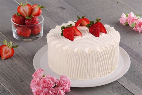 Fotografía de un pastel de fresas recién horneado, con las fresas en la parte superior y un borde dorado.