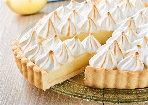 Foto de un pie de limón entero con merengue dorado sobre una base de galletas de vino