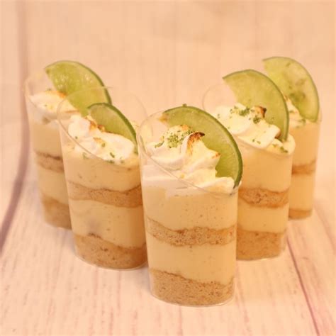 Foto de varios shots individuales de pie de limón sin horno, decorados con merengue y ralladura de limón