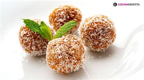 fotografía de bolitas de coco y dulce de leche dispuestas en una fuente decorada con hojas de menta fresca