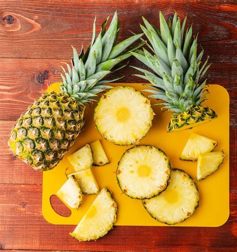 Piña fresca y en rodajas sobre una tabla de cortar, resaltando su color amarillo vibrante.