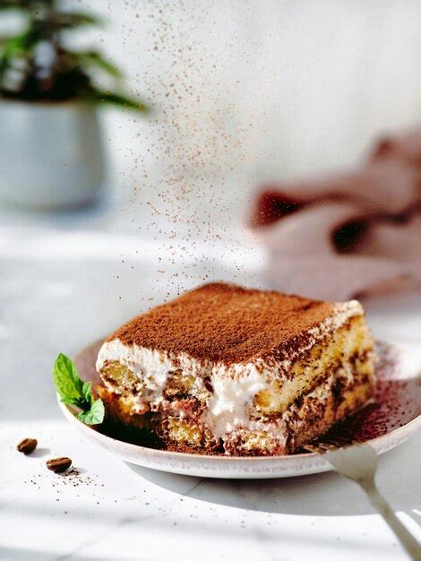 Tiramisú clásico en porciones, espolvoreado con cacao