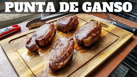 Primer plano de carne de punta de ganso siendo preparada en la plancha con el caldo característico