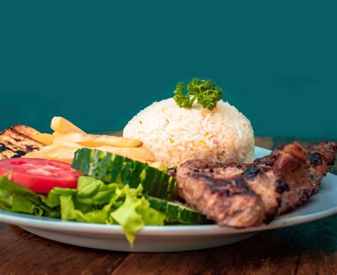 Plato típico de pollo a las brasas servido con arroz y acompañamientos clásicos