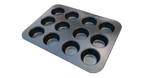 Molde para cupcakes con cápsulas de papel y masa distribuida uniformemente.