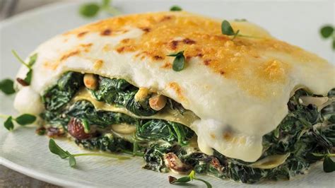 Plato de lasaña de espinaca recién horneado con una capa superior dorada y cremosa