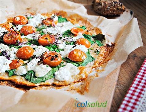 Pizza de pollo sin harina terminada, con queso fundido y toppings coloridos.