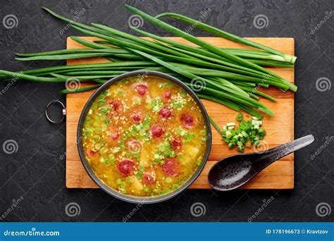Tazón de sopa de arveja amarilla humeante con hierbas frescas