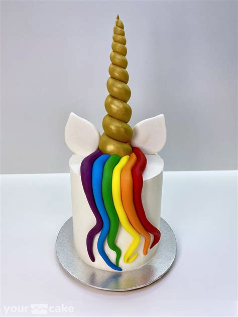 Esquema visual que muestra las partes de la tarta de unicornio: capas de bizcocho, cobertura, melena de flores de crema y elementos modelados (cuerno y orejas).