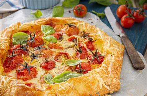 Tarta Caprese casera recién horneada, con masa rojiza y relleno de tomate, mozzarella y albahaca