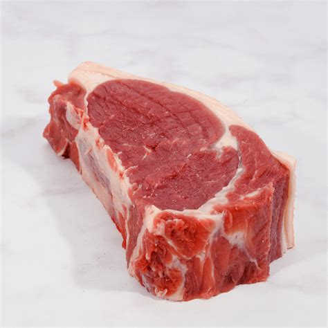 Fotografía de un bife de chorizo crudo resaltando el marmoleo y la capa de grasa externa