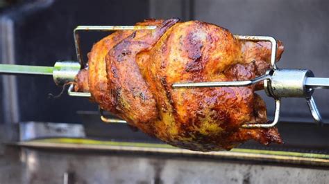 pollo asado girando lentamente en un asador rotatorio