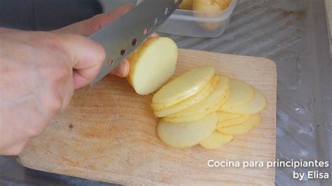 Molde para hornear con capas alternas de rodajas de papa y salsa cremosa.