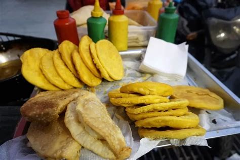 Puesto callejero de sopaipillas con varios aderezos