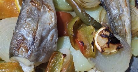 fotografía de diversos pescados listos para entrar al horno sobre una cama de verduras