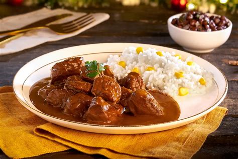 pierna de jabalí en un recipiente, cubierta con adobo y papel film, en el frigorífico