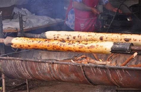Chochoca preparada con harina y papas asándose sobre un palo chochoquero en Chiloé
