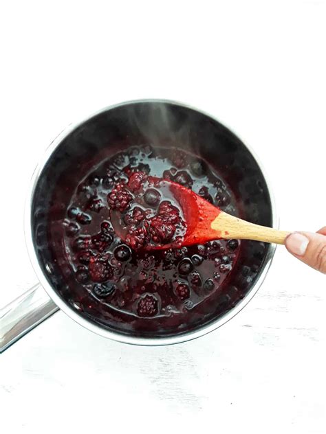 Olla con frutos rojos cociéndose a fuego lento.