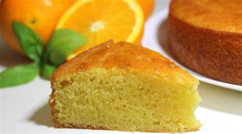 Una rebanada de torta de naranja esponjosa y húmeda en un plato, con ralladura de naranja de decoración.