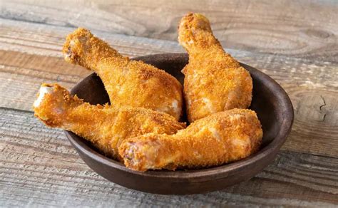 Imagen de tiras de pollo empanado con coco en una bandeja para hornear