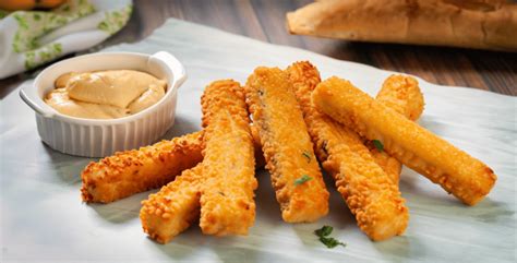 Foto de palitos de queso apanados dorados en un plato, listos para servir