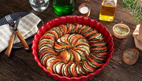 Montaje de ratatouille estilo película, verduras en espiral sobre salsa