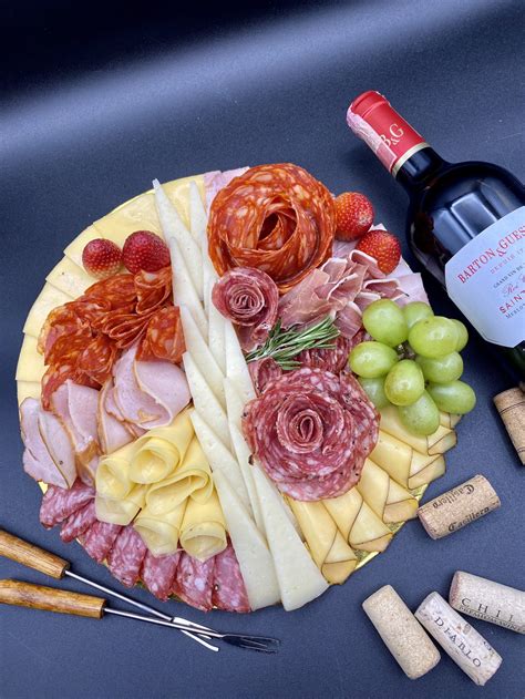 Imagen de una tabla de quesos y embutidos con una copa de vino tinto Cabernet Franc