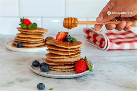 Imagen de tortitas de Nestum apiladas, decoradas con frutas frescas y un chorrito de miel.