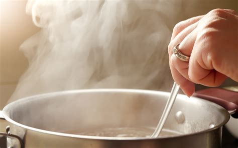 Pescado cocinándose a fuego lento en un caldillo con vegetales