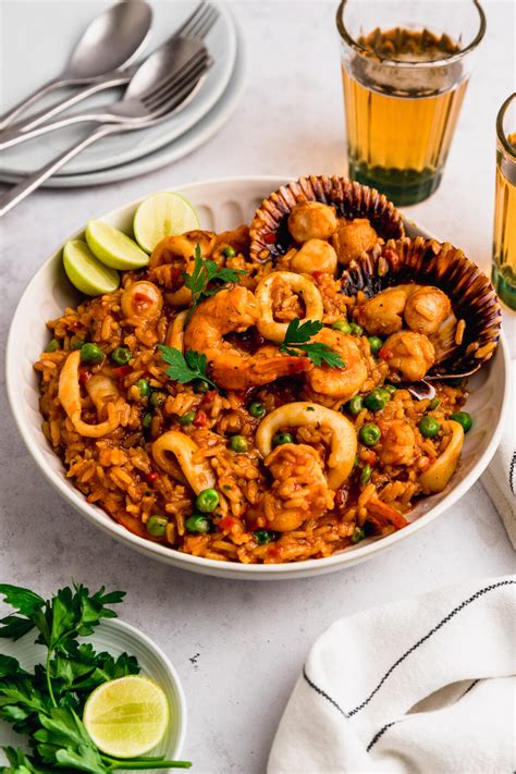 Arroz con mariscos peruano en plato, vista superior, con limón y perejil
