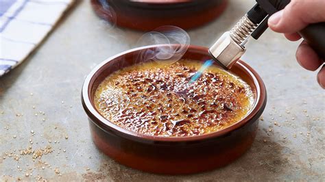 Crème brûlée servida en ramequines con una capa de caramelo crujiente y frutos rojos