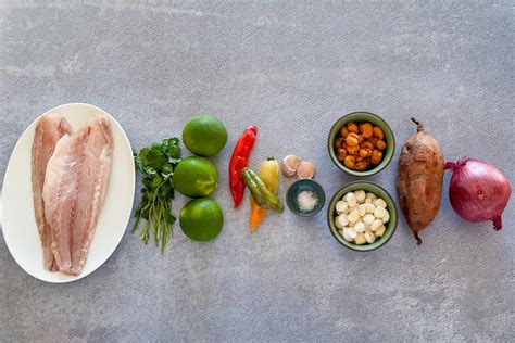 Imagen de los ingredientes del ceviche de mariscos: surtido de mariscos, cebolla morada, pimentones de colores, limones frescos, cilantro.