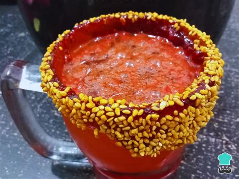 Primer plano de un vaso escarchado con la base de michelada y hielo, listo para la cerveza