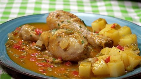 Ingredientes frescos para guiso de pollo: muslos de pollo, patatas, cebolla, tomate, laurel.