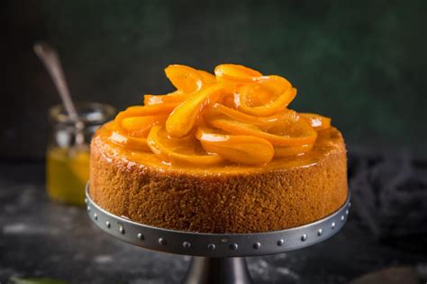 Torta de naranja decorada con glaseado y rodajas de naranja fresca y confitada