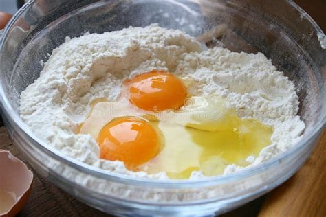 Ilustración de un bol con harina formando un volcán, con los ingredientes secos en el centro y líquidos alrededor.