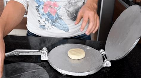 Placa de horno con bolas de masa aplastadas y pinchadas con un tenedor.