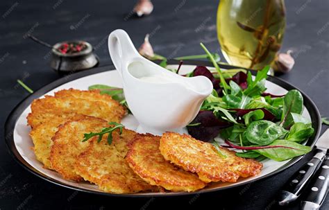 Panqueques de papa dorados servidos con crema agria y ciboulette