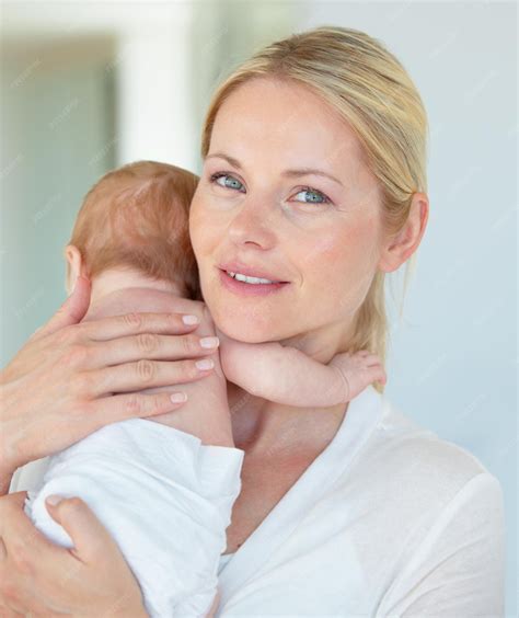 Una madre acunando a su bebé, intentando calmarlo.