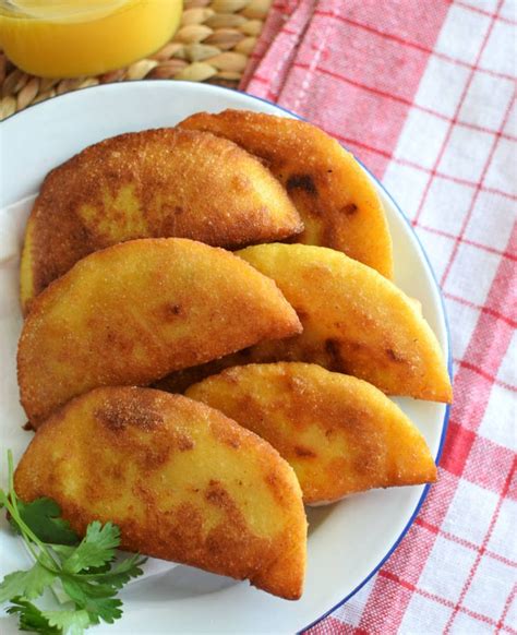Fotografía de una empanada venezolana crujiente servida con salsas tradicionales