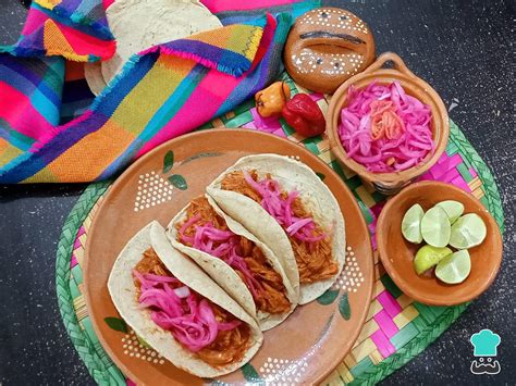 Fotografía de platillos mexicanos como tacos o cochinita pibil donde la cebolla morada encurtida es un acompañamiento destacado.