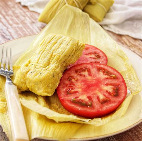 Humitas tradicionales chilenas servidas en un plato con ensalada de tomate